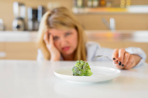 femme aux prises avec son régime alimentaire - overweight women salad frustration photos et images de collection