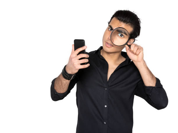 istock man examines mobile phone with magnifying glass 1128831517