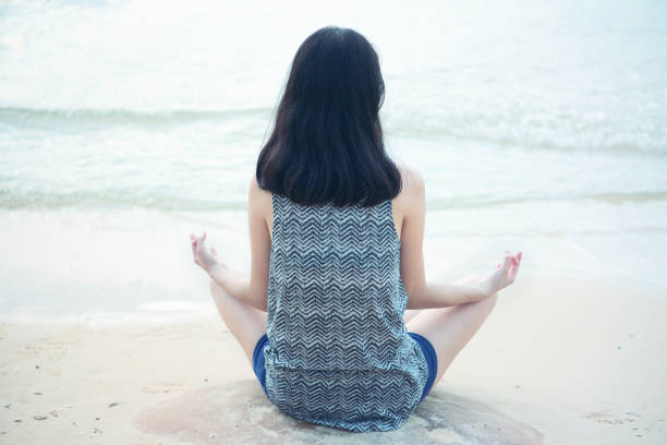 istock Woman meditate on the beach 1128833322