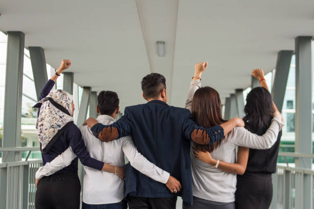 istock rear view of unrecognizable business Team With Arms Around One Another 1128833382
