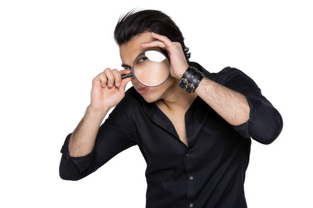 istock man in a black shirt looks through a magnifying glass 1128833825