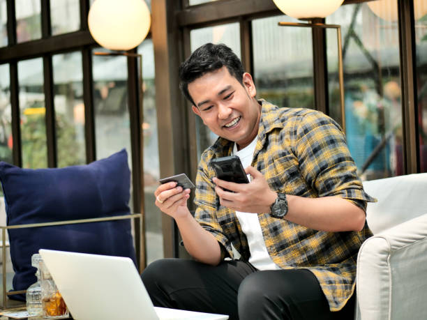 istock Making online bank transfer, man holds a credit card while entering data in laptop 1128834830