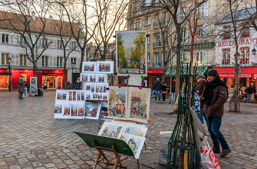 Paris, France - January 20, 2015: Artists awaiting customers amongst easels and artwork set up in Place du Tertre in Montmartre