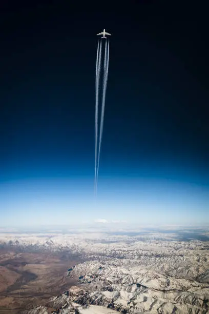 airliner in front of sky scene with intense contrails. Showing air pollution and exhaust