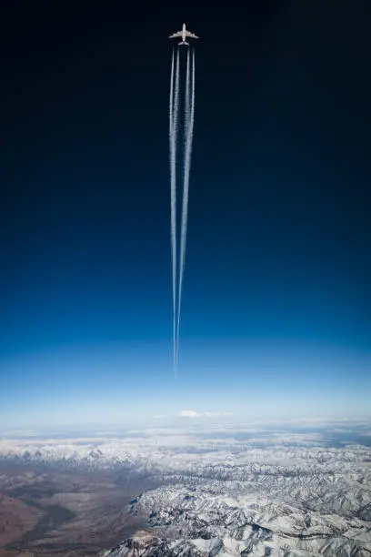 airliner in front of sky scene with intense contrails. Showing air pollution and exhaust