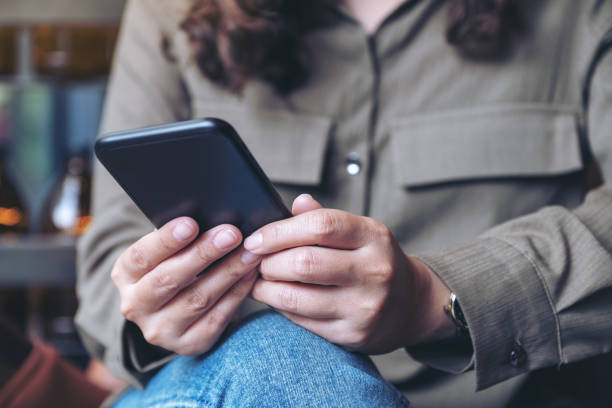 istock a woman holding , using and looking at smart phone 1128843699