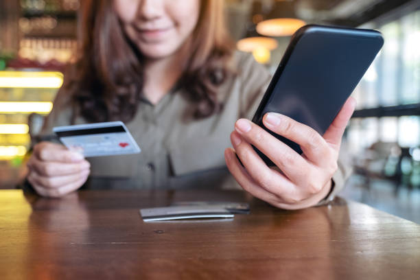 istock a woman holding credit card and using mobile banking 1128843899