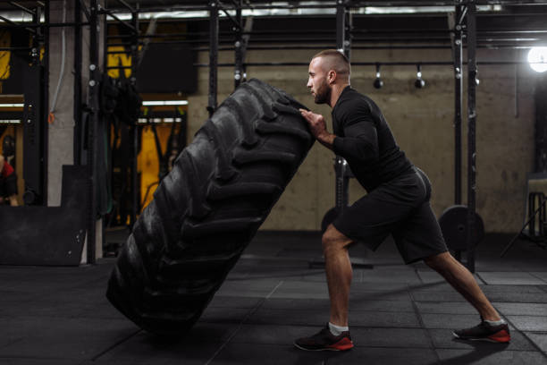 istock physical exercises with tire, heavy things 1128844960