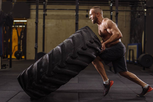istock young ambitious sportsman is concentraiting on his training with heavy tire 1128844983