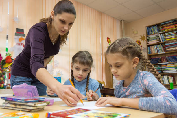 istock The teacher helps the students in drawing class 1128845141