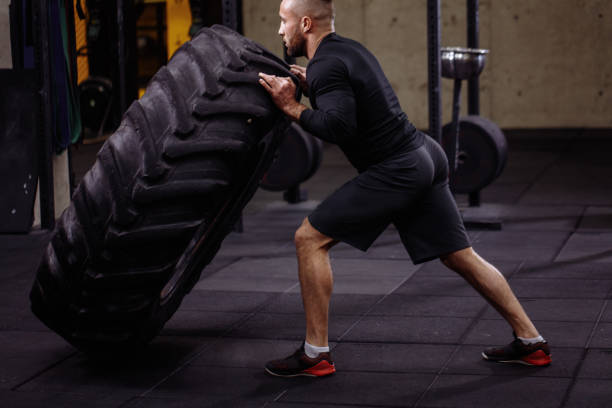 istock fit man is raising a weight from the ground 1128848257