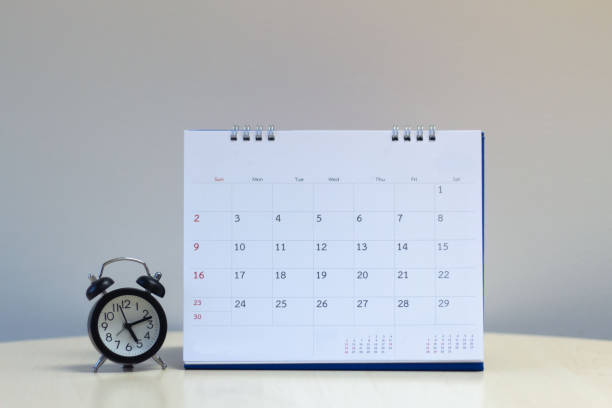istock Calendar with alarm clock on desk table - Time management concept. 1128849277