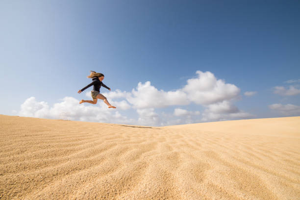 istock Beautiful child playing in the dunes 1128850389