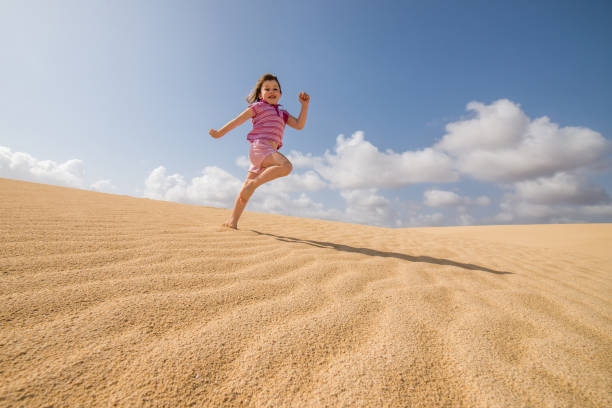 istock Beautiful child playing in the dunes 1128850390
