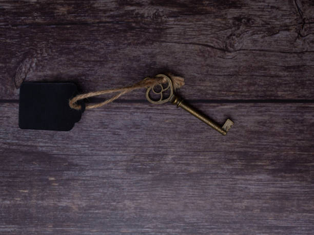 istock Home key with tag on wood table background, property concept, copy space 1128850860