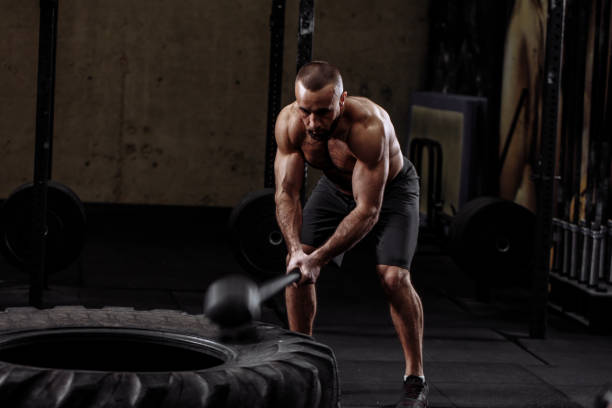 istock a muscular brutal man is slaming down the tire 1128851594