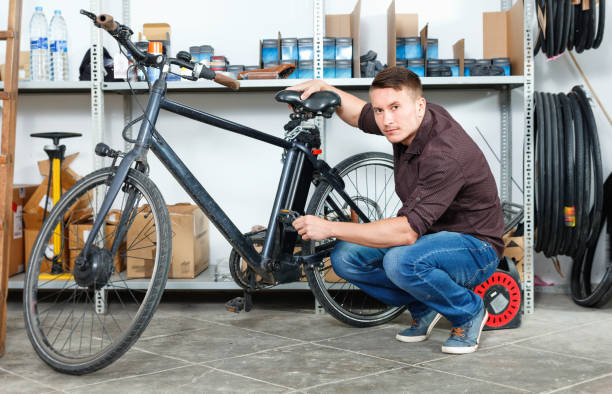 istock Man is pumping the bicycle wheels in the workshop. 1128852433