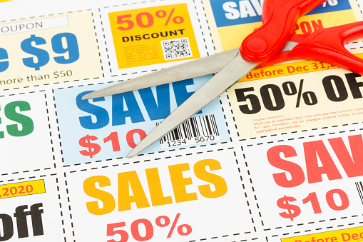 Saving discount coupon voucher with scissors, coupons are mock-up
