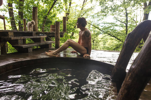 istock wet, strong guy is sitting and looking at his pet after sauna 1128853369