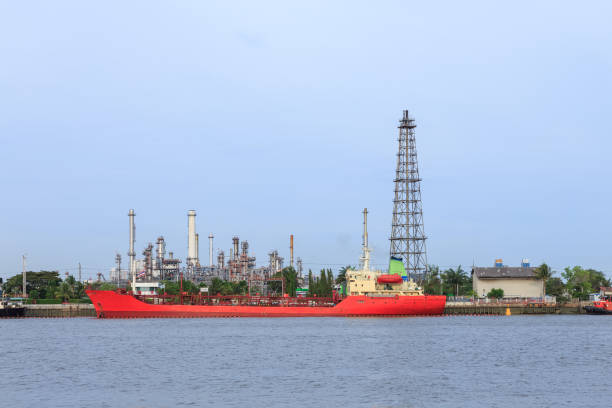 istock Oil refinery on water front and oil tanker 1128853813