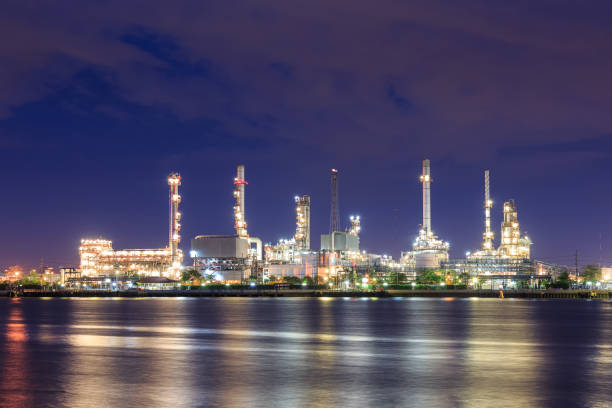 istock Oil refinery on water front at night 1128853824