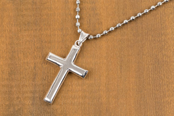 istock Silver cross with necklace on wooden background 1128856978