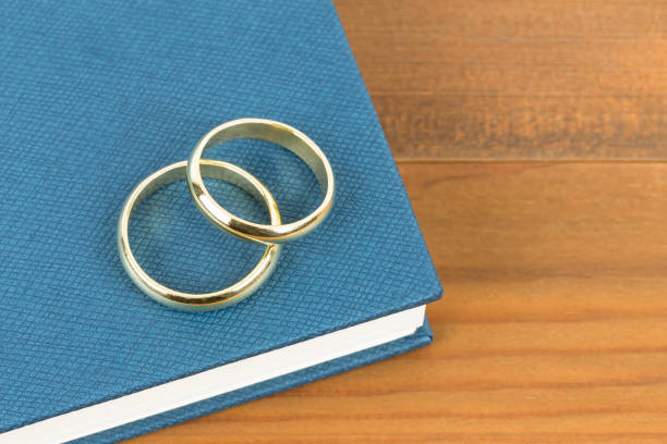 istock Gold wedding rings on blue bible book 1128857010