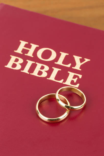 istock Gold wedding rings on red bible book cover 1128857018