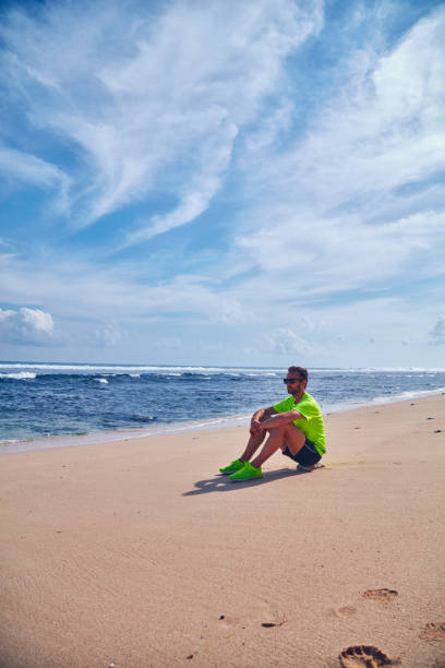 istock Sportsman stretching on a exotic tropical beach after jogging / exercising. 1128858701