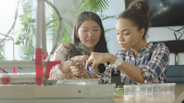 istock Young multi-ethnic female engeneers soldering device prototype 1128858854
