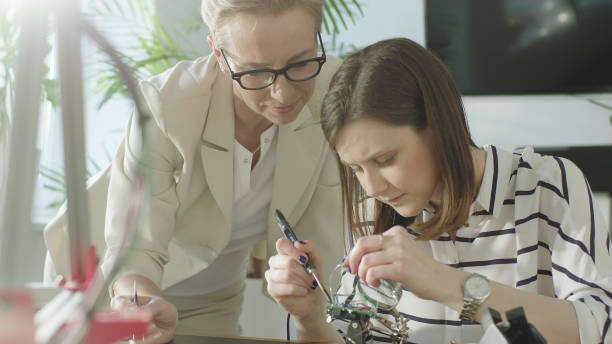 istock Young female engeneer teached how to solder 1128858907