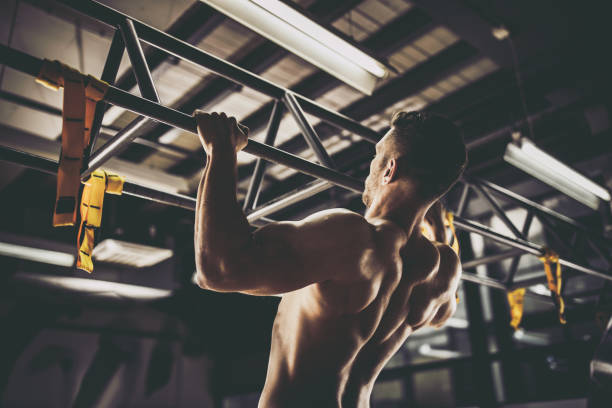 vue arrière de l’homme athlétique exercer des tractions dans un gymnase. - masculinity photos et images de collection