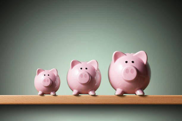 Three piggy banks on the shelf. 	Small, medium and large. Three piggy banks on the shelf. Small, medium and large. piccolo stock pictures, royalty-free photos & images