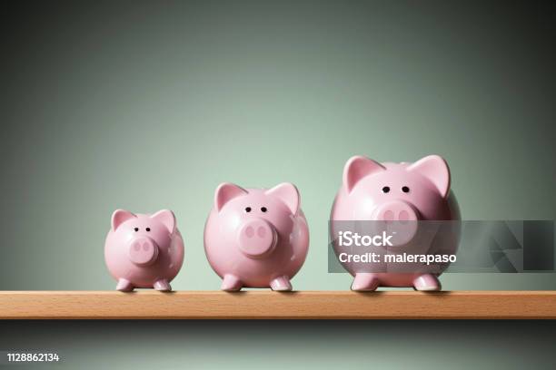 Three Piggy Banks On The Shelf Small Medium And Large Stock Photo - Download Image Now