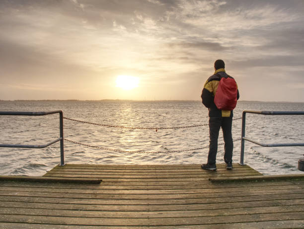 istock Man walk. Idyllic ocean beautiful dark cloud endless horizon 1128866070