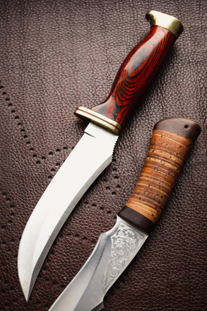 istock Two hunting knifes on brown background. 1128866497