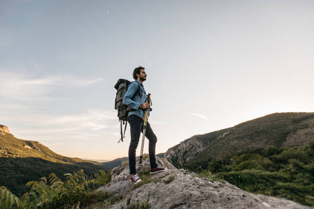 istock Man hiker standing on mountain rock alone 1128867842