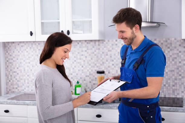 istock Woman Signing Invoice In Kitchen 1128872894