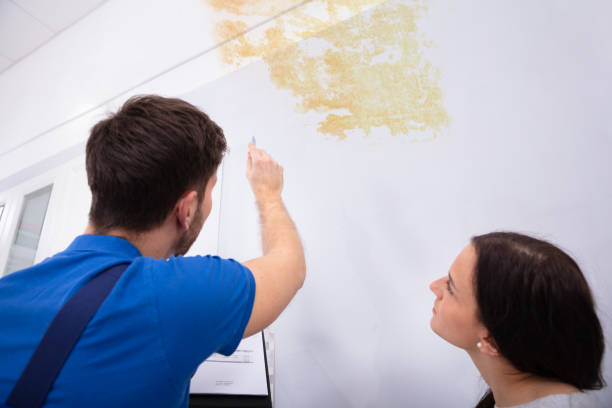 istock Worker Writing On Clipboard With Woman Standing 1128872920