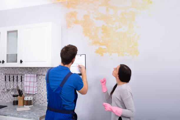 istock Worker Writing On Clipboard With Woman Standing 1128872921