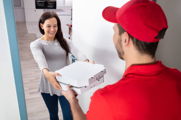 istock Man Delivering Pizza To Woman 1128873403