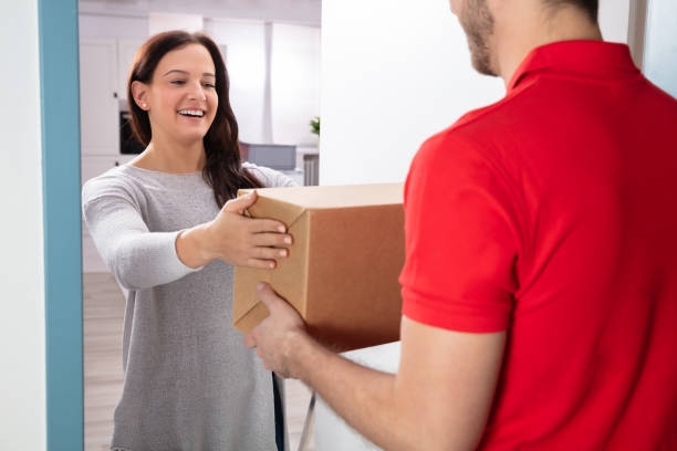 istock Woman Taking Box From Delivery Man 1128873426