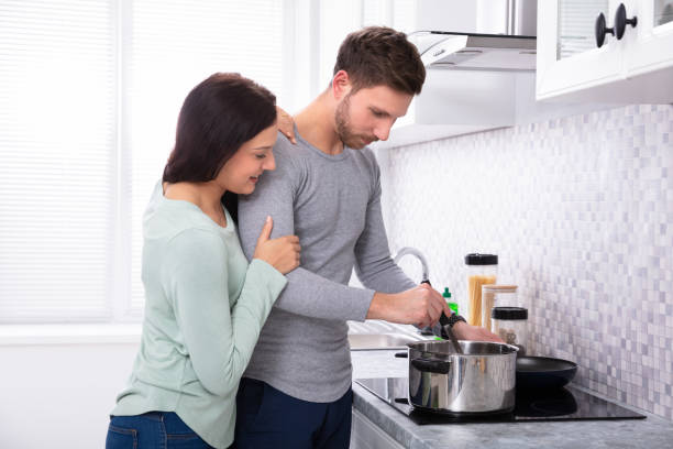 istock Husband And Wife Making Food In Kitchen 1128873488