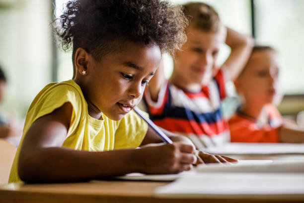 istock African American girl writing in notebook in the classroom. 1128875233