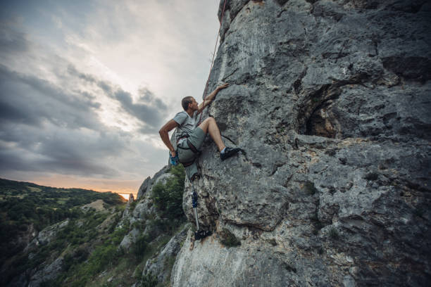 istock Disability climber climbing high on rocky mountain 1128875485