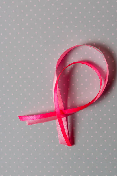 istock Red ribbon breast cancer awarerness over gray  background and copy space for text. 1128876340