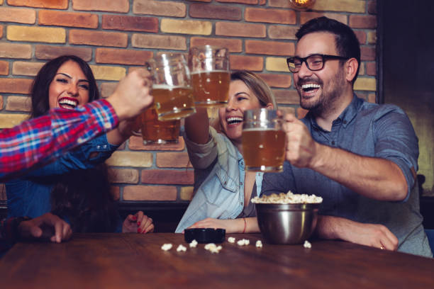 istock Group Of Friends Enjoying Evening Drinks In Bar 1128876573