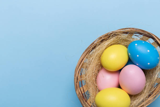 istock Colorfull easter eggs in nest on blue pastel color background with space. 1128876854