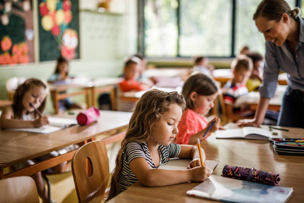 istock Schoolgirl writing a dictation during a class in elementary school. 1128877855