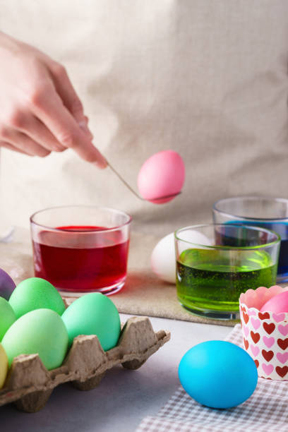 istock Painting Easter eggs concept. Male hand holding colorful egg. 1128878292